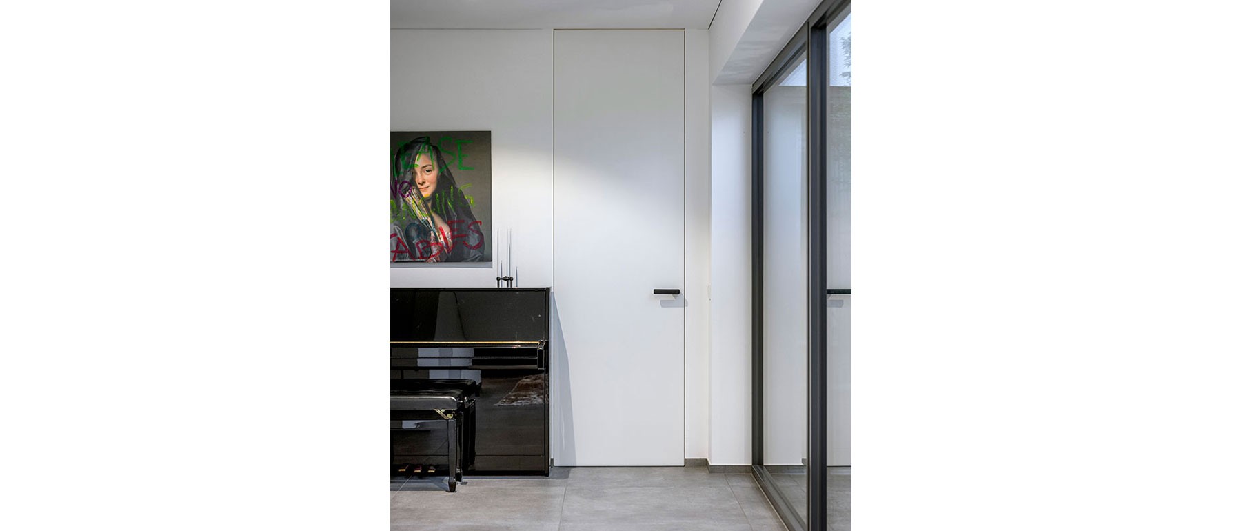 Raumhohe Tür im modernen Holzhaus mit Blick auf den zentralen Innenhof 